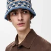 Kapelusz typu bucket z naszywką, wykonany z rafii i skóry cielęcej, wykonany techniką szydełkowania Kapelusz typu bucket z naszywką, wykonany z rafii i skóry cielęcej, wykonany techniką szydełkowania