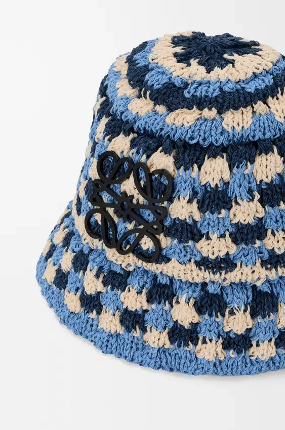 Kapelusz typu bucket z naszywką, wykonany z rafii i skóry cielęcej, wykonany techniką szydełkowania Kapelusz typu bucket z naszywką, wykonany z rafii i skóry cielęcej, wykonany techniką szydełkowania